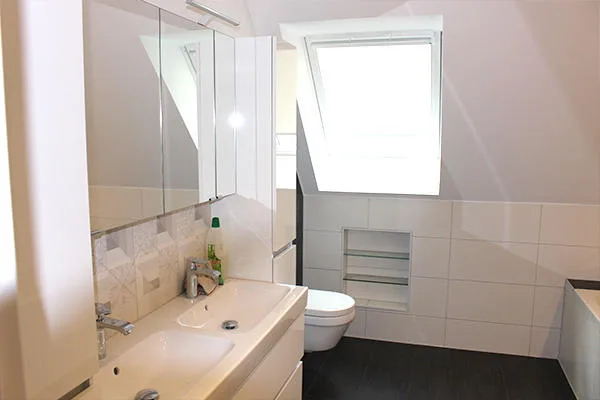 Fertiggestelltes Bad mit Dusche unter einer Dachschräge